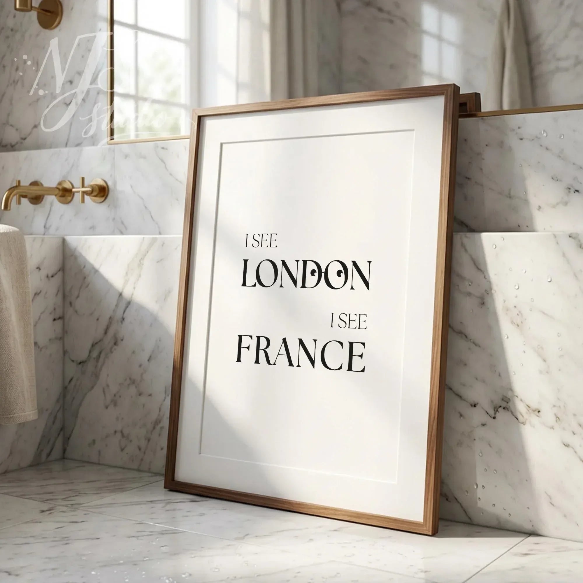 Funny bathroom wall art print with the quote “I See London I See France,” leaning against a tiled wall near a sink with soft daylight.
