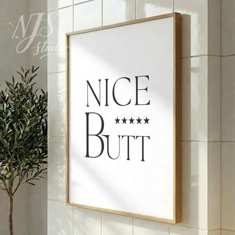 Modern bathroom quote print featuring “Nice Butt” and star rating, styled in a vertical wood frame on tiled flooring.