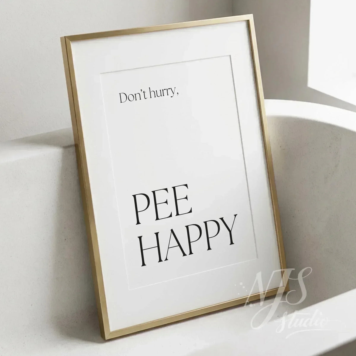 Minimal bathroom wall art featuring the quote “Don’t hurry, Pee Happy,” displayed in a slim gold frame beside a modern bathtub.