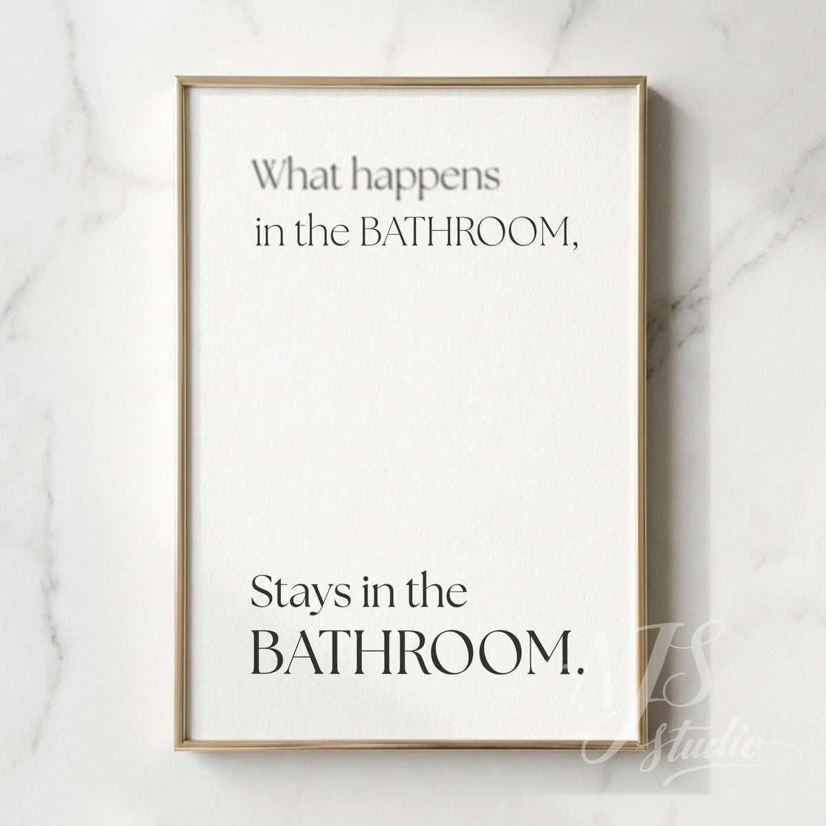 Minimal bathroom wall art featuring the quote “What happens in the bathroom, stays in the bathroom,” displayed in a slim gold frame on a marble wall.