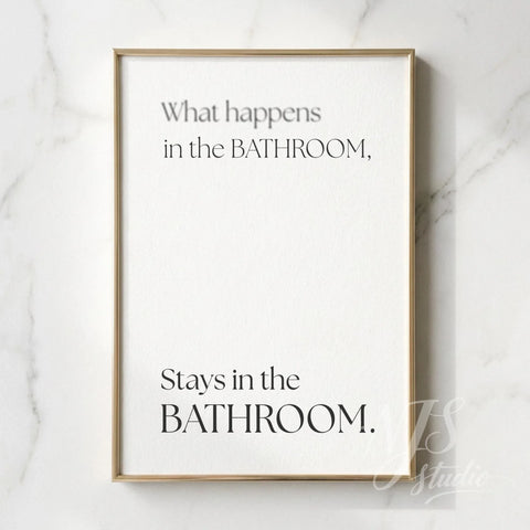 Minimal bathroom wall art featuring the quote “What happens in the bathroom, stays in the bathroom,” displayed in a slim gold frame on a marble wall.