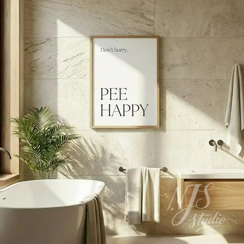Funny bathroom quote print reading “Don’t hurry, Pee Happy,” hung above a freestanding bathtub in a bright spa-style bathroom.
