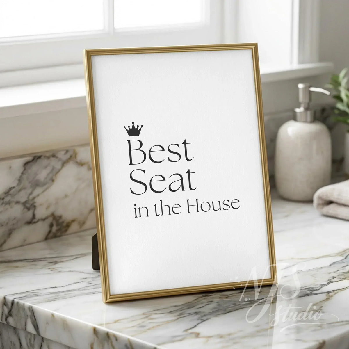 Minimal bathroom counter decor featuring the quote “Best Seat in the House” in elegant black typography, displayed in a gold frame on a marble vanity surface.