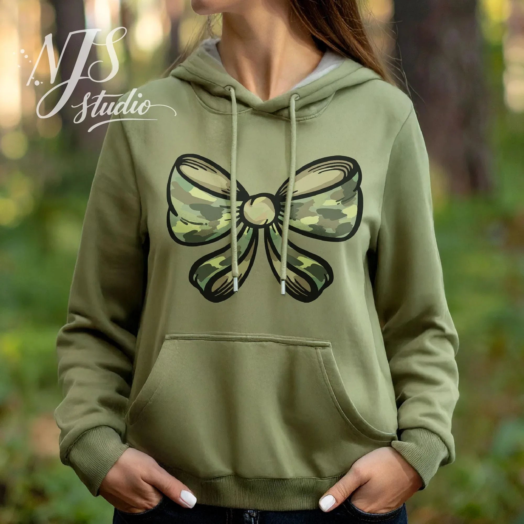 Olive green hoodie with a camouflage bow illustration, styled in a forest setting for outdoor leisure wear