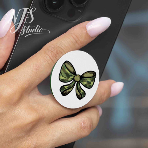Hand holding a smartphone with a round phone grip printed with a camouflage bow illustration