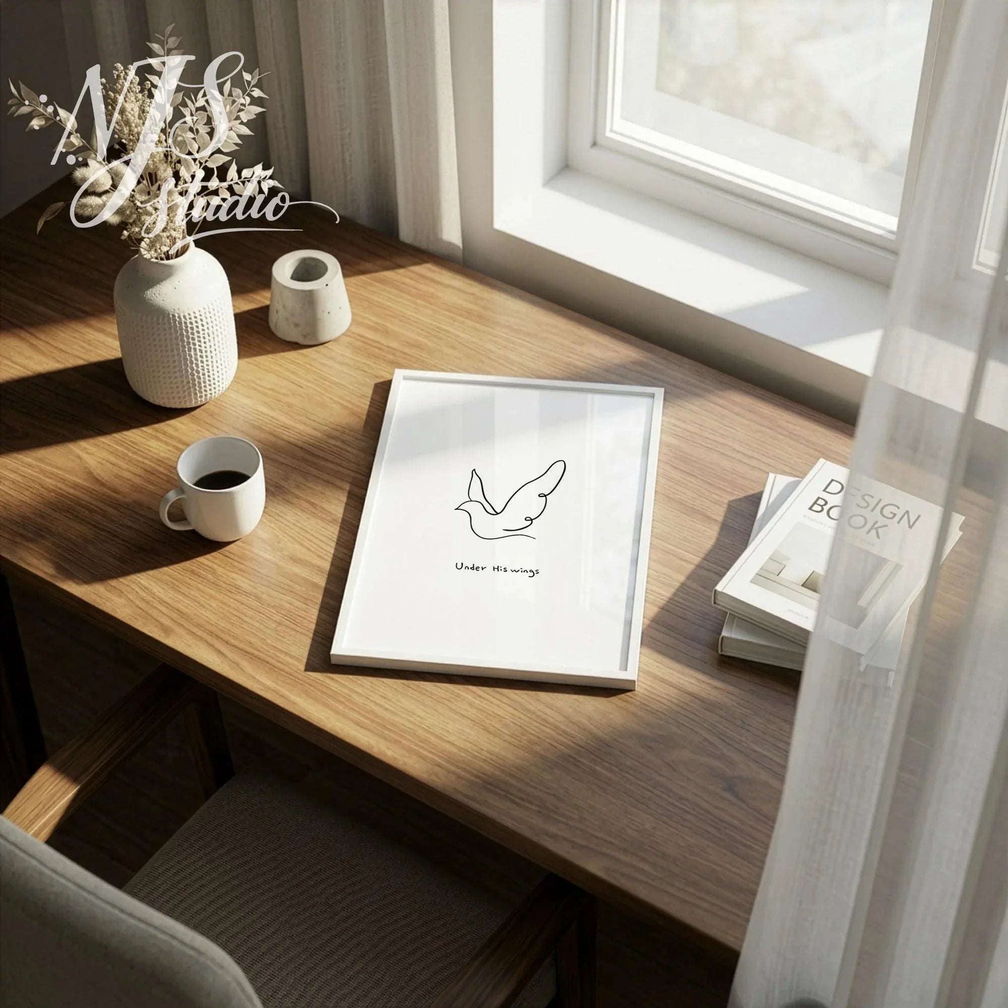 Minimal scripture art print on a wooden desk next to a vase of dried flowers and coffee mug.