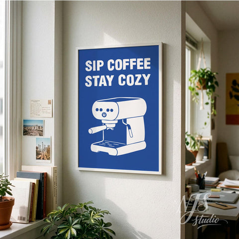 Framed poster with 'Sip Coffee Stay Cozy' text and coffee machine illustration on a wall.