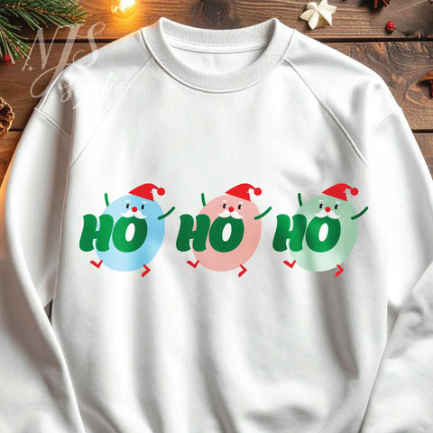 White crewneck sweatshirt flat lay with green, pink, and blue Santa clipart design.