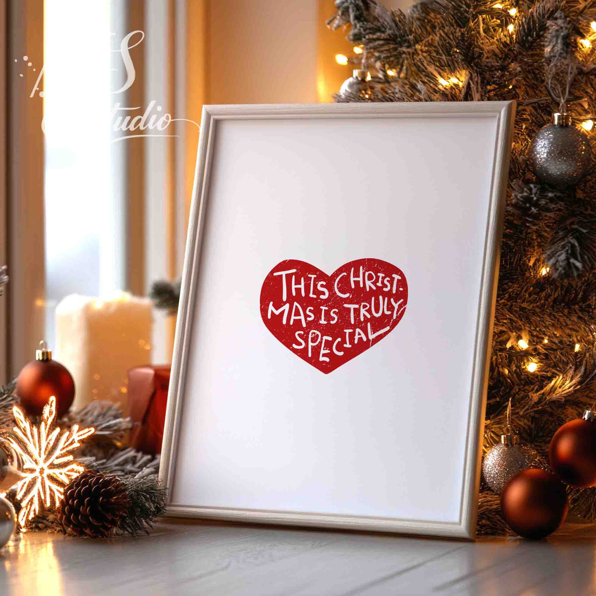 Framed red heart Christmas typography print standing on a shelf with ornaments and warm lights.