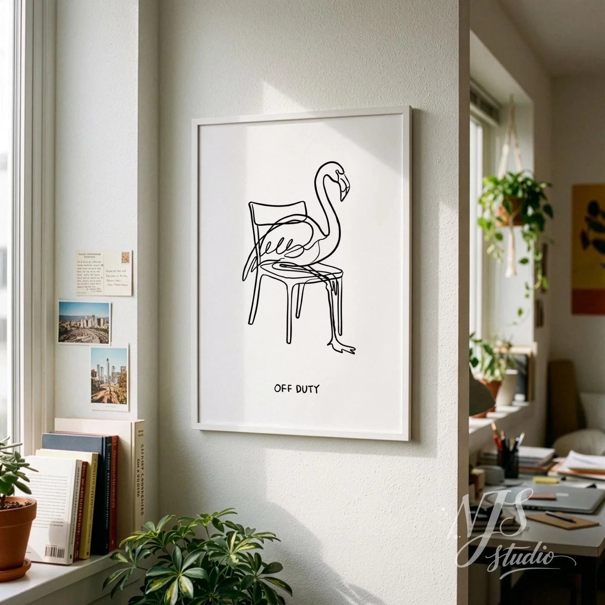 Minimal flamingo line art wall print with Off Duty text displayed in cozy Scandinavian style living room with plants and books
