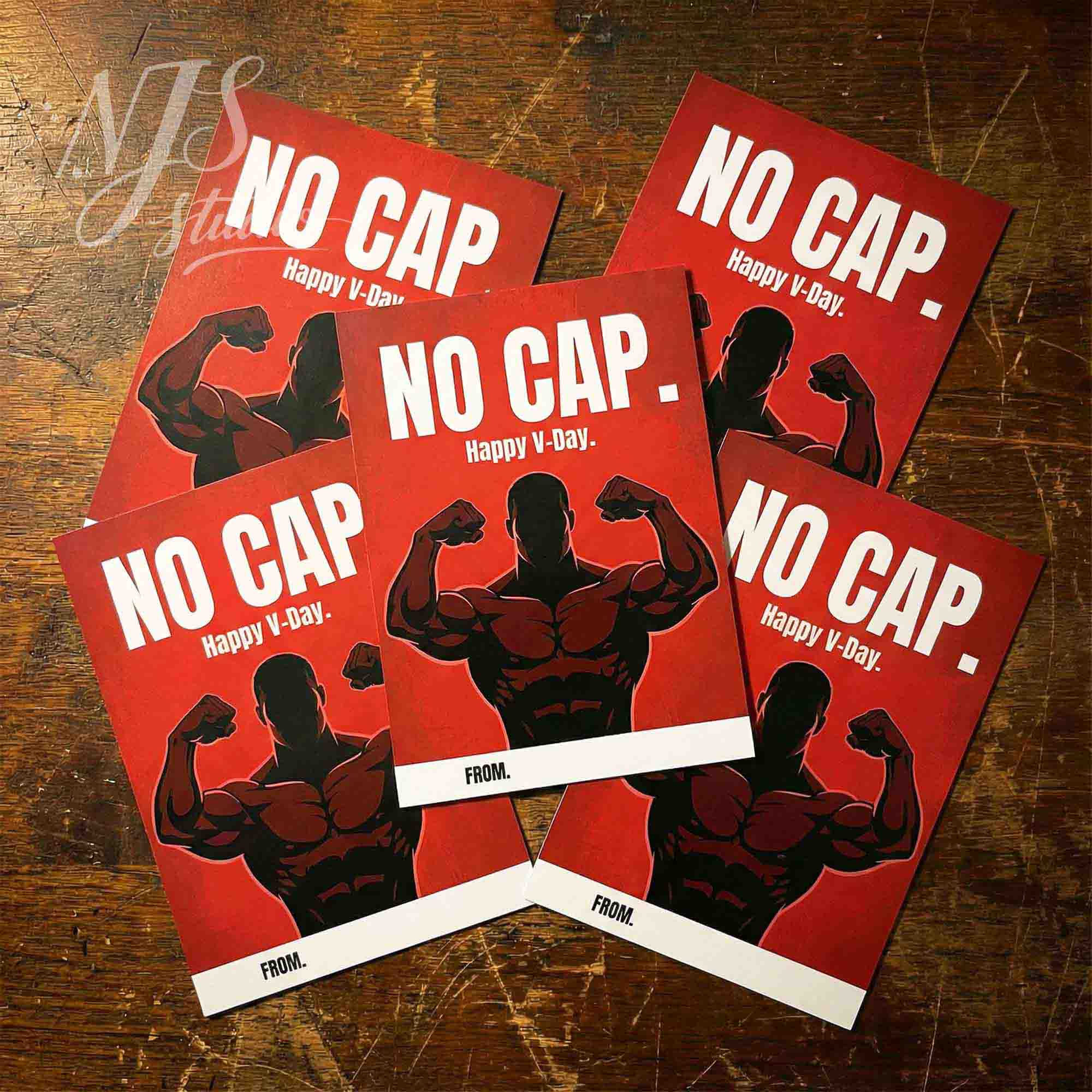 Funny No Cap Valentine cards with flexing cartoon bodybuilder, flatlay on wood, NJS studio