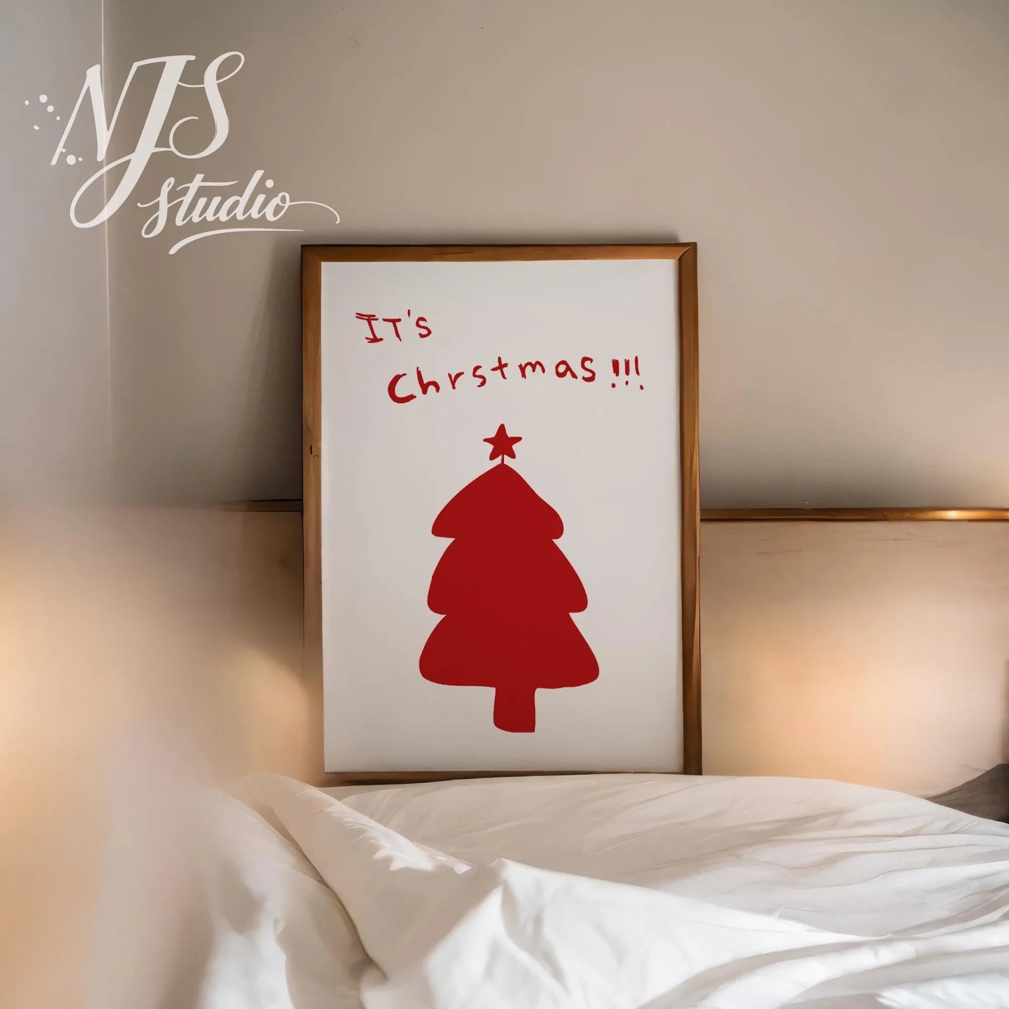 Simple Its Christmas typography poster leaning against a wall in a cozy bedroom setting.