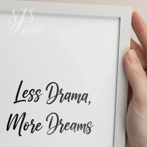 Close up of hand holding a white framed print showing the artistic gradient detail in the word Dreams.