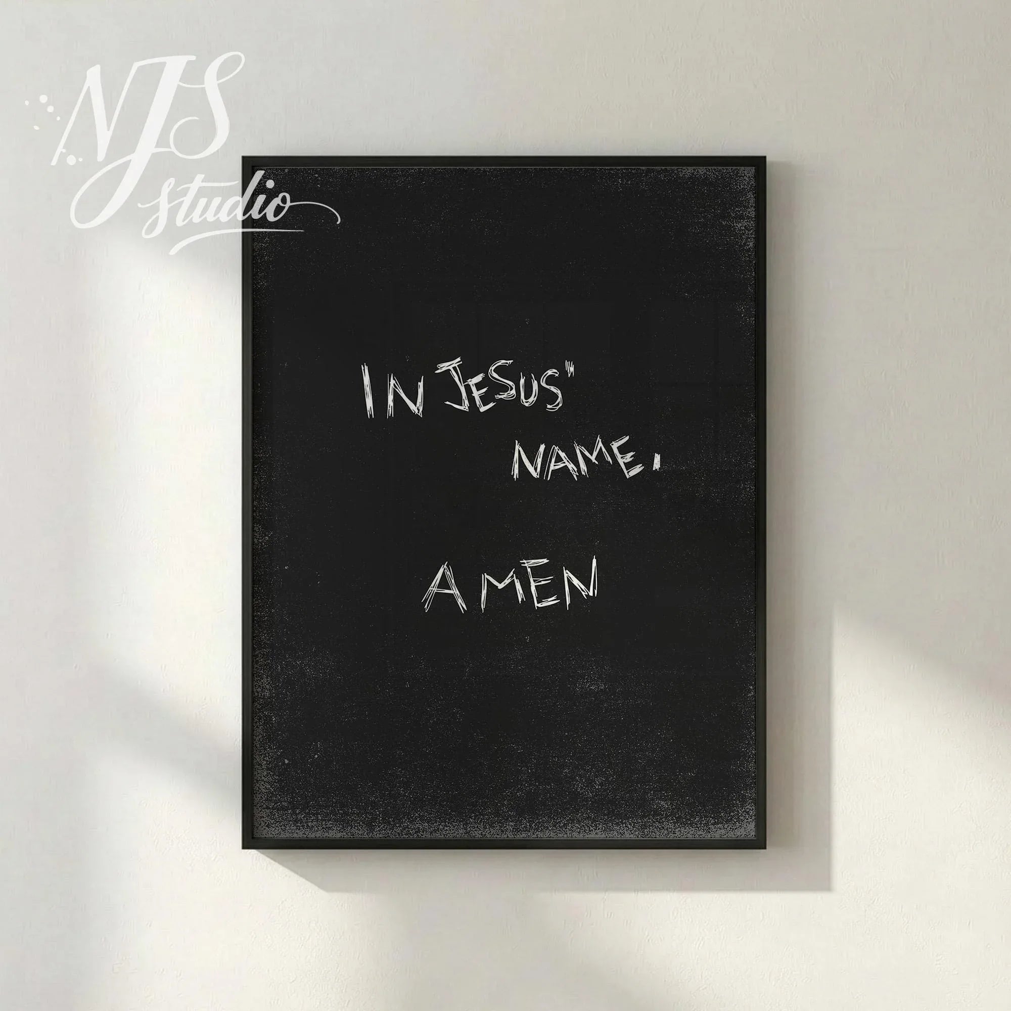 Black textured poster with handwritten “In Jesus’ Name, Amen” displayed in simple frame on neutral wall, modern Christian faith decor.