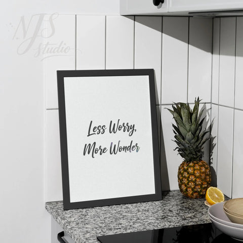 Black framed typography print standing on a kitchen counter next to a pineapple, home styling.