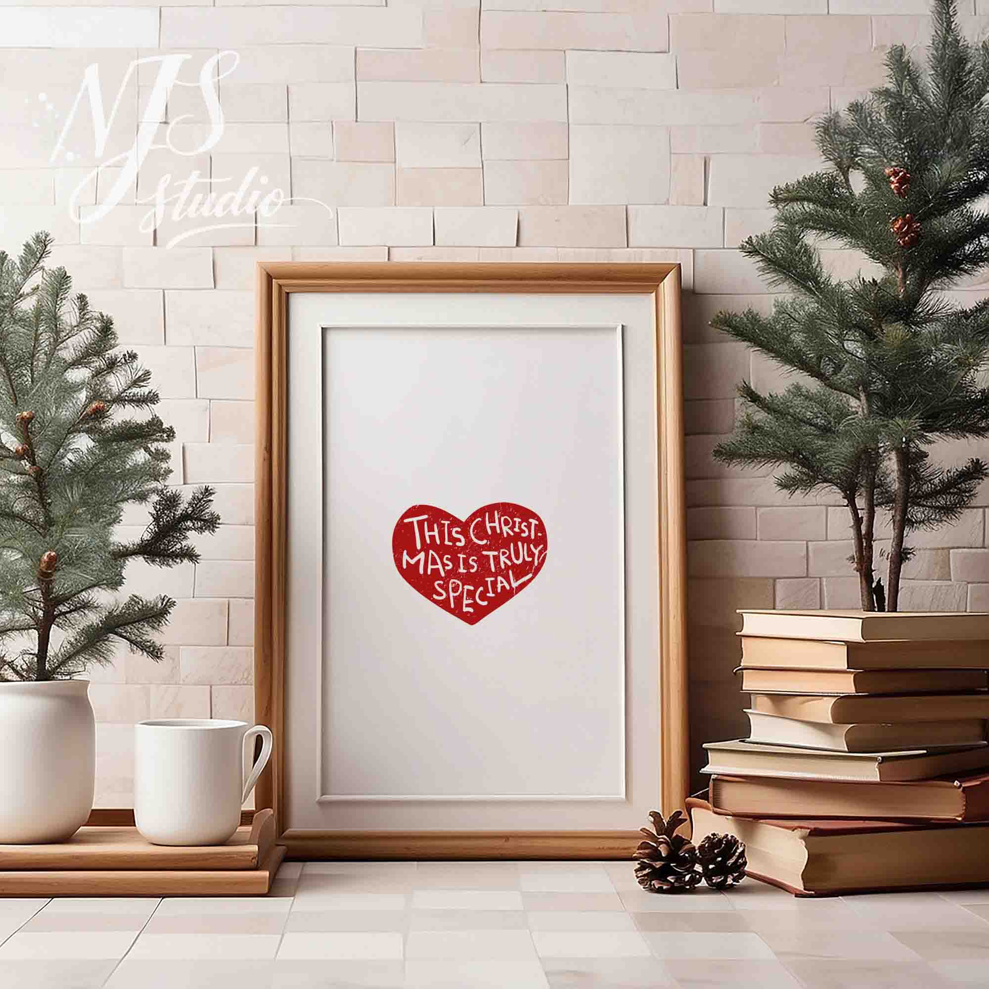 Wood framed holiday poster with red heart graphic saying This Christmas Is Truly Special on a table with mini trees.