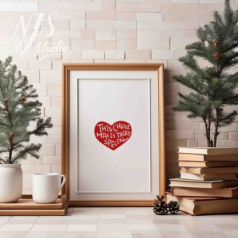 Wood framed holiday poster with red heart graphic saying This Christmas Is Truly Special on a table with mini trees.