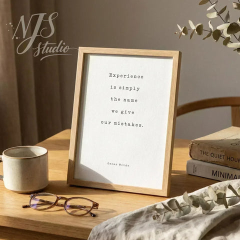 Wood framed literary quote standing on a wooden desk with reading glasses and old books.