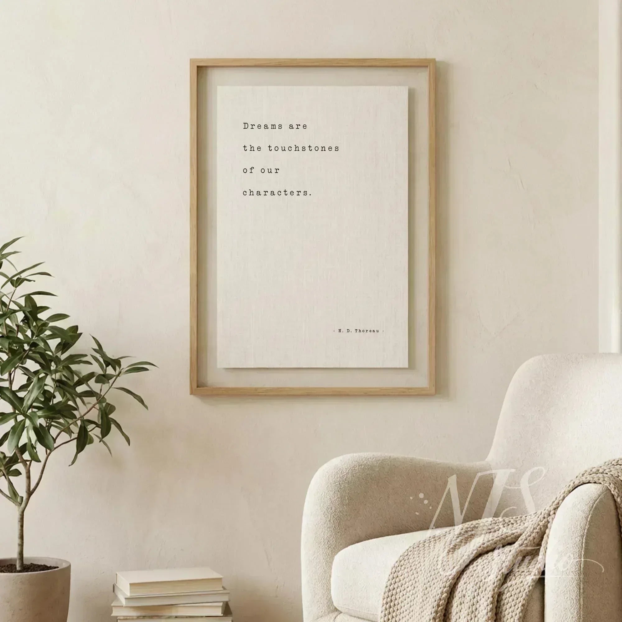 Large framed literary quote print hanging on a beige wall next to a comfortable armchair.