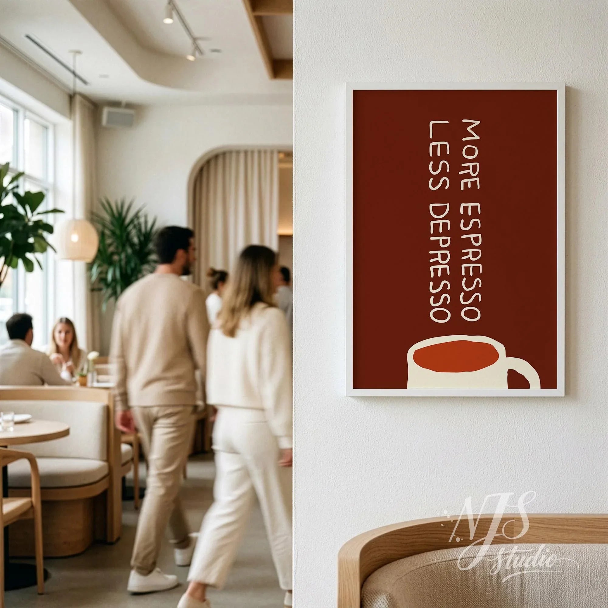 Large framed brown coffee quote print hanging on a white wall in a cozy cafe setting with people walking.