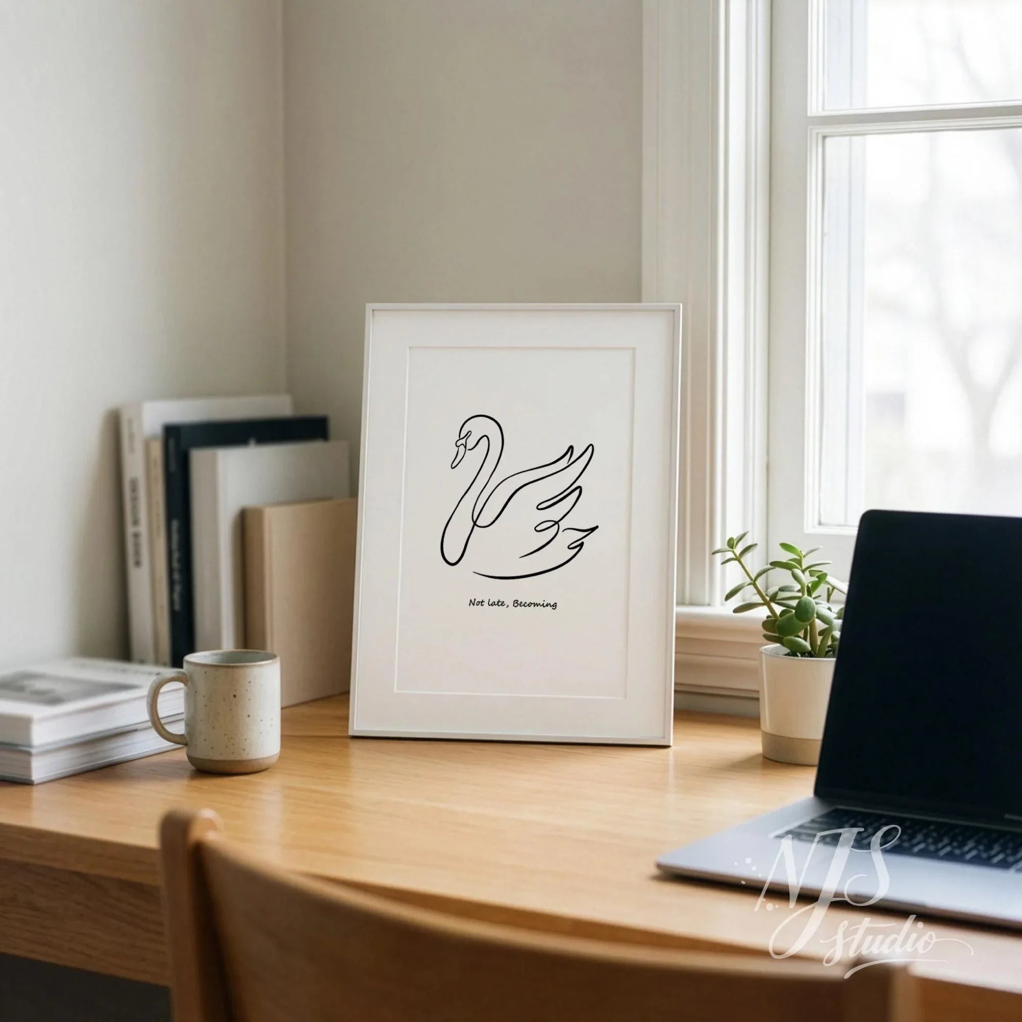 Minimal swan line art wall print in white frame on wooden desk with books, coffee cup, and plant, modern Scandinavian home office decor