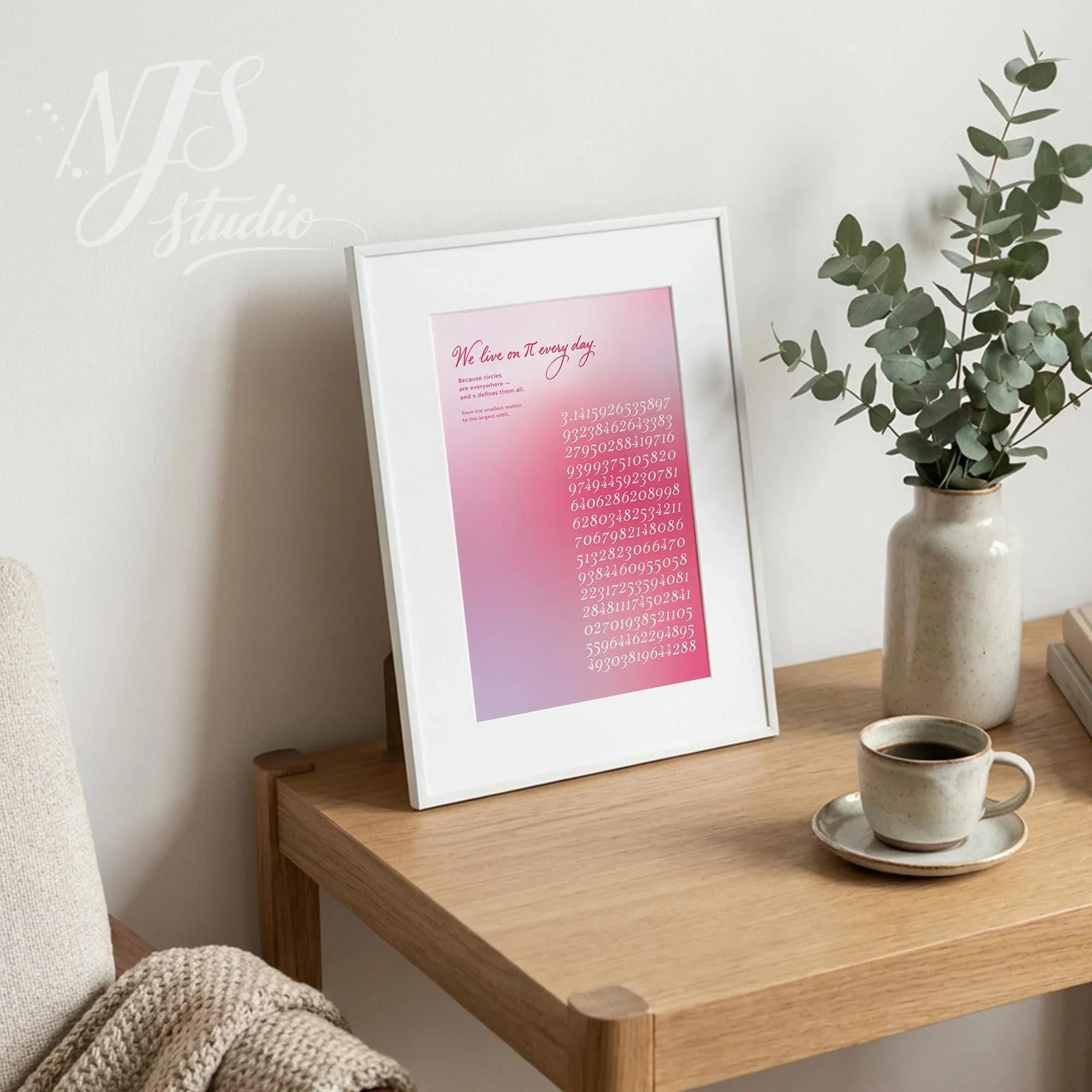 Framed pi digits art print styled on a wooden table next to a coffee cup and ceramic vase