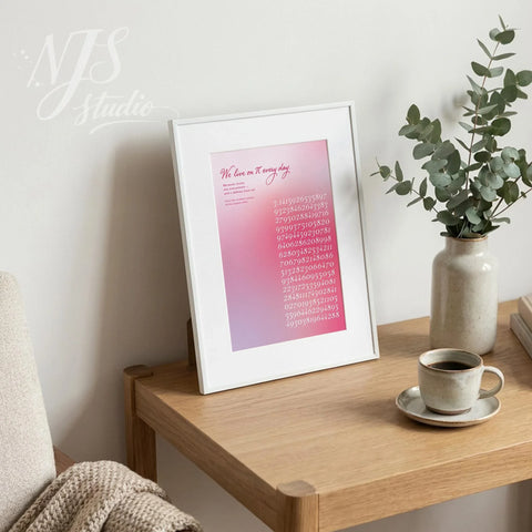 Framed pi digits art print styled on a wooden table next to a coffee cup and ceramic vase