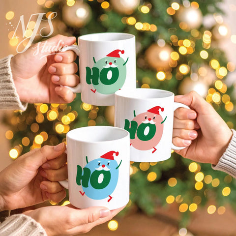 Three hands toasting with white coffee mugs featuring colorful round Santa character prints.