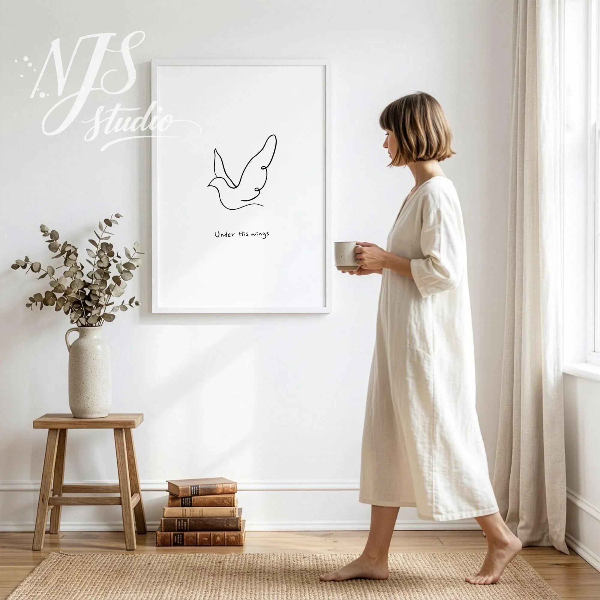 Woman in a white dress walking past a large framed simple Christian line art poster on a white wall.