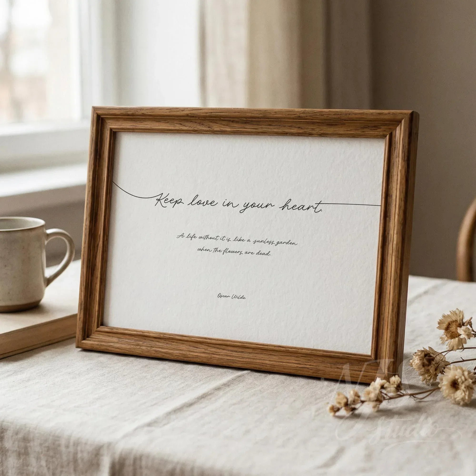 Rustic wood framed inspirational quote standing on a table with a coffee mug and dried flowers.